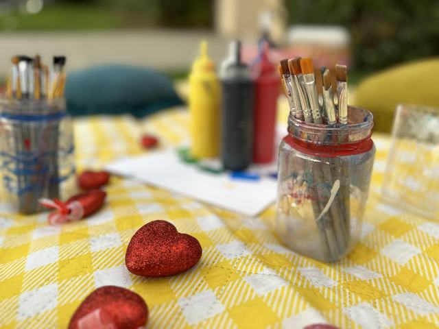 Brushes and paint on a gingham picnic setup