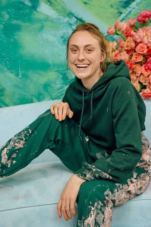 Lilly O'Brien seated in front of her painting